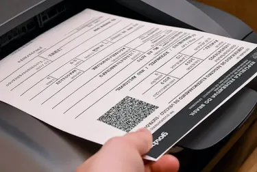 Atendente executando a impressão do CRLV-e com documentos de veículos.